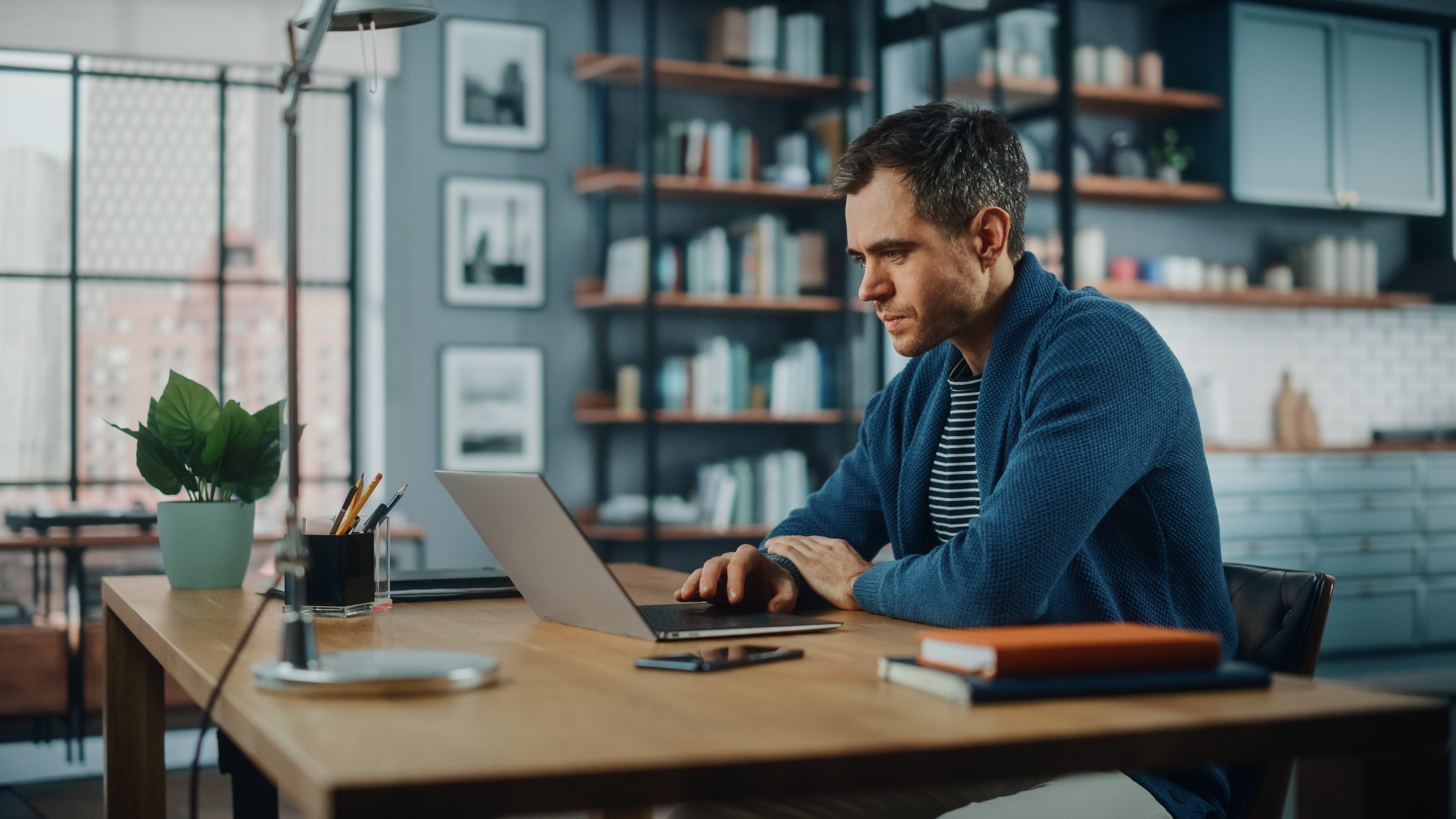 Handsome Caucasian Man Working on Laptop Computer while Sitting Behind