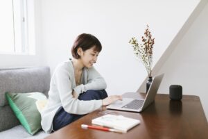 Distance Working - young woman using laptop to work and to keep in touch with friends and family.