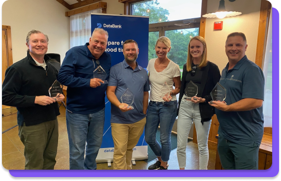 Group of DataBank employees holding awards